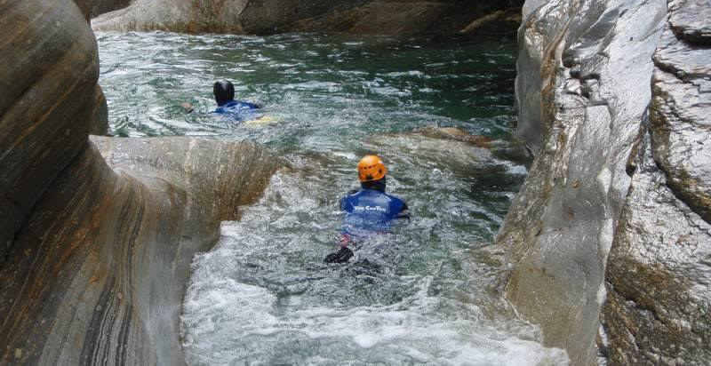 Tuffo in una pozza cristallina durante il canyoning in Val Bodengo
