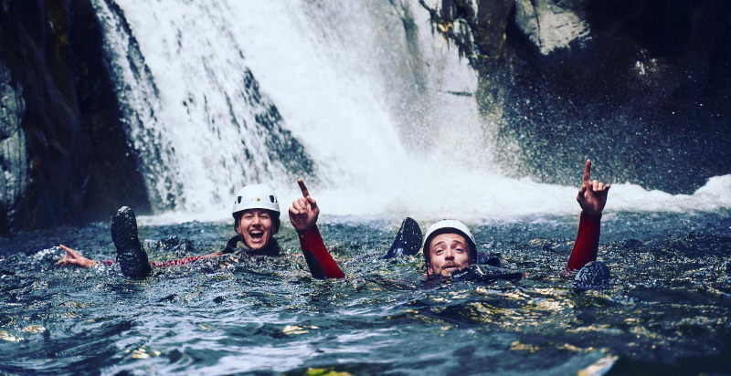Escursionisti durante il canyoning, immersi in acque naturali di montagna