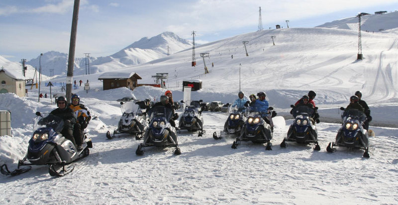 Gruppo di persone che guidano motoslitte tra i paesaggi innevati di Livigno