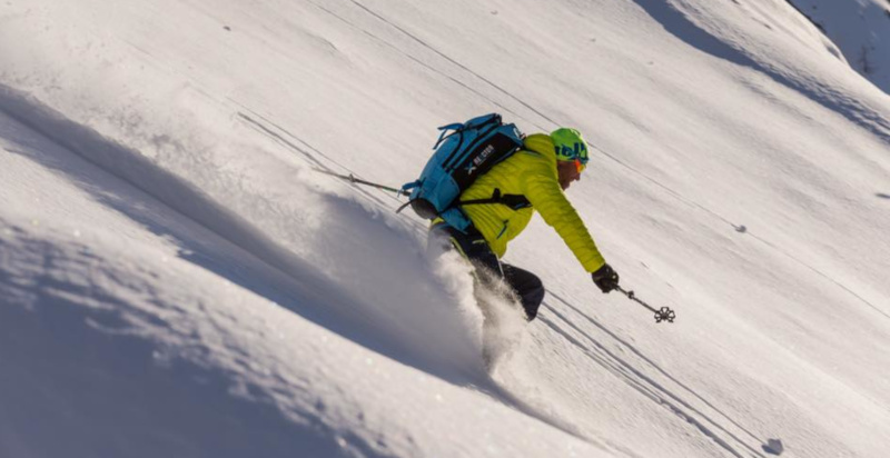 Guida alpina accompagna un gruppo in freeride sulle Alpi
