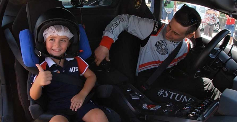 Bambino seduto in sicurezza su una Lamborghini guidata da un istruttore esperto