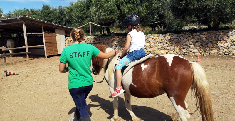 lezione di equitazone per bambina nel parco di asinolla