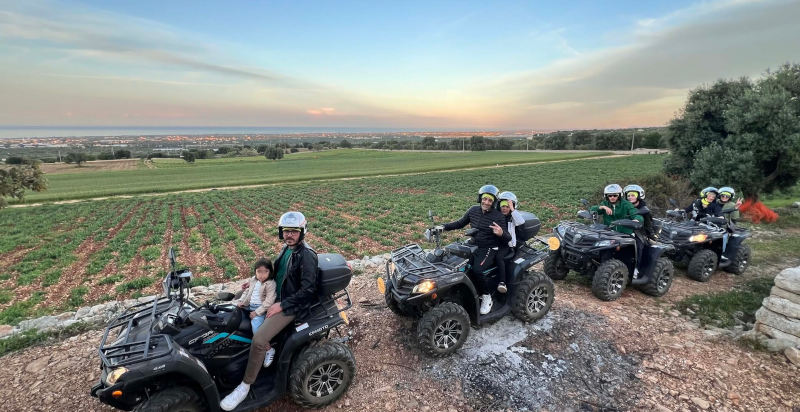 Partecipanti con casco a bordo di un quad biposto pronto per il tour monopoli
