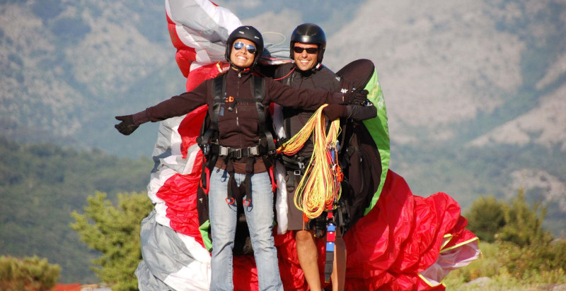 Pilota e passeggero dopo l'atterraggio del volo con parapendio tandem