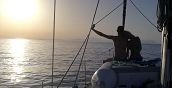 Coppia si abbraccia al tramonto sulla barca a vela