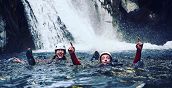 Escursionisti durante il canyoning, immersi in acque naturali di montagna