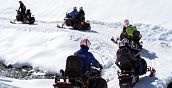 cinque motoslitte con conducenti e passeggeri durante un tour in zona Sestriere