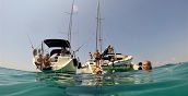 Tuffo nel mare blu del Salento durante l'escursione in barca con attrezzatura per snorkelling