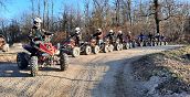 Gruppo di persone che guidano quad elettrici in un percorso naturale