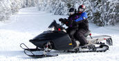 Coppia in sella ad una motoslitta a Livigno