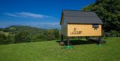 Esperienza glamping nella StarsBOX del Rifugio Pranolz circondata dai prati verdi della Valbelluna