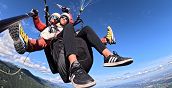 Pilota e passeggero in volo con il parapendio biposto sul Monte Grappa.