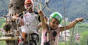 famiglia che si diverte nel Parco Avventura tra gli alberi del Trentino