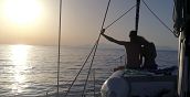 Coppia ammira il tramonto durante un'escursione in barca a vela sul Gargano