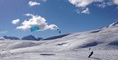 Atleta di snowkite sulla cresta di una collina innevata
