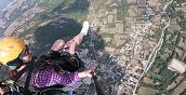 Pilota di parapendio con passeggero in volo sopra il paesaggio abruzzese