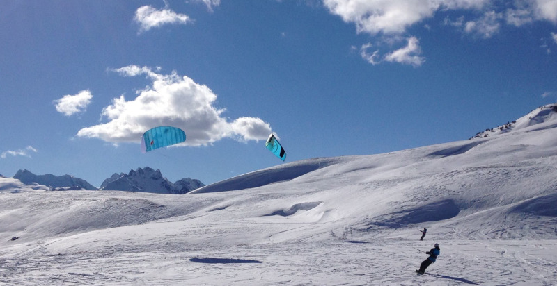 Atleta di snowkite sulla cresta di una collina innevata