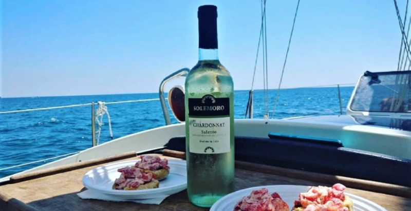 Aperitivo con prodotti tipici locali a bordo durante l'escursione in barca nel Salento