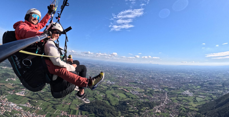 Volo in parapendio biposto sopra Borso del Grappa con vista panoramica sulla pianura veneta.