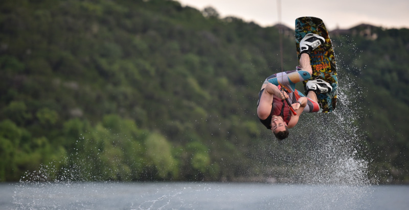 Atleta che esegue un salto spettacolare durante una sessione di wakeboard sul Lago di Garda